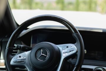 Close-up of a luxury car steering wheel showcasing sleek design elements.