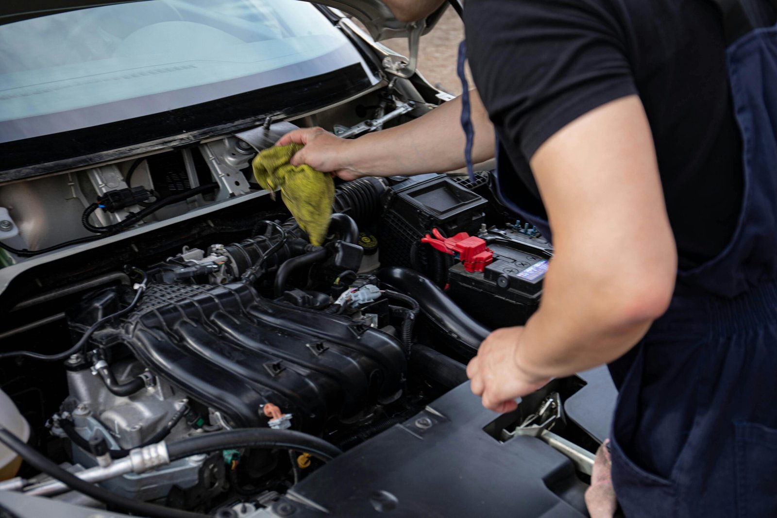 Close-up of mechanic repairing a car engine, focusing on maintenance and cleaning.